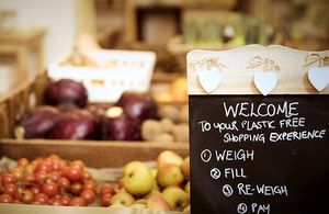 A welcome chalkboard with vegetables in the background.