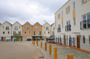 Suburban houses and flats with bollards on the edge of the pavement.