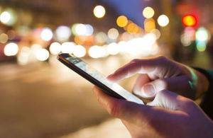 Anonymous image of someone using a phone in the street