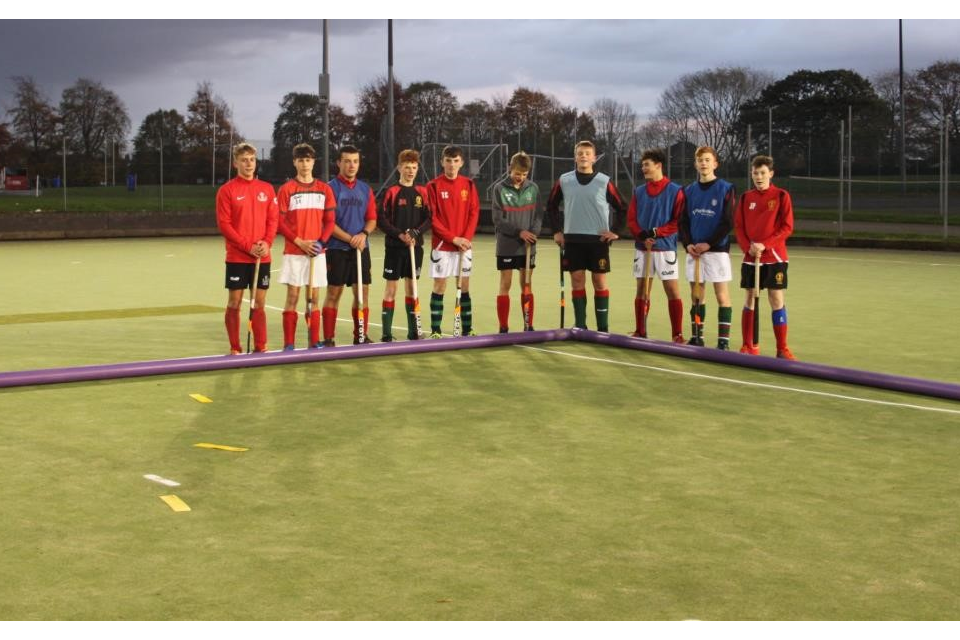 Hockey team at the school standing by the purples pipes