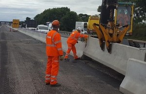 Contractors working on the road with the purple pipes in view