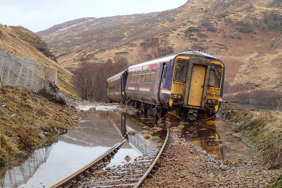 The two-car derailed train on the moors at Loch Eilt showing the submerged line and landslide. 
