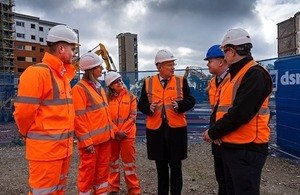 Construction site vistors wearing protective clothing talking to each other.