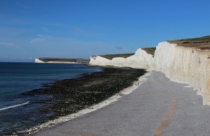 White cliffs overlooking the ocean against a blue sky.