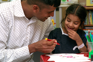 Adult carer talking to child in school