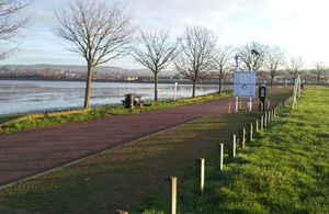 Photo of large body of water on left next to a track in a park