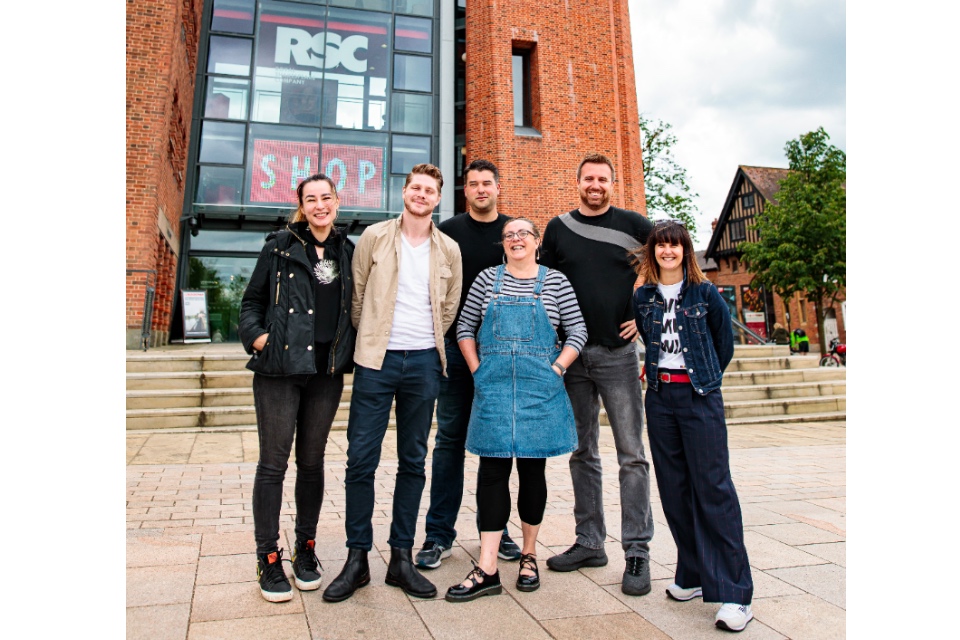 Six digital theatre fellows standing in front of the Royal Shakespeare Company building in Stratford