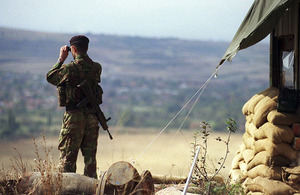 A sentry watches through a pair of binoculars in Kosovo.