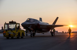 An F-35 jet is pictured against a sunset sky