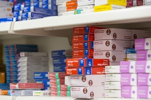 Packets of medicines on a pharmacy shelf.