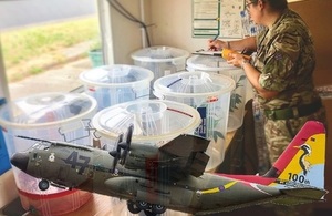 RAF Hercules superimposed over a member of RAF personnel dealing with waste products.