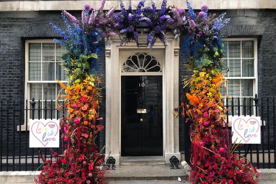 Flowers in the rainbow flag colours surrounding the Downing Street door.