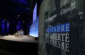 Media Freedom conference logo with panel seating in the distance