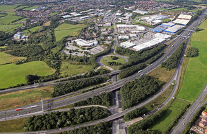 Aerial view of a section of motorway, with junctions and a town