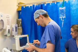 Hospital doctors standing around a patient in bed