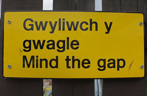 Mind the gap sign in Welsh and English.