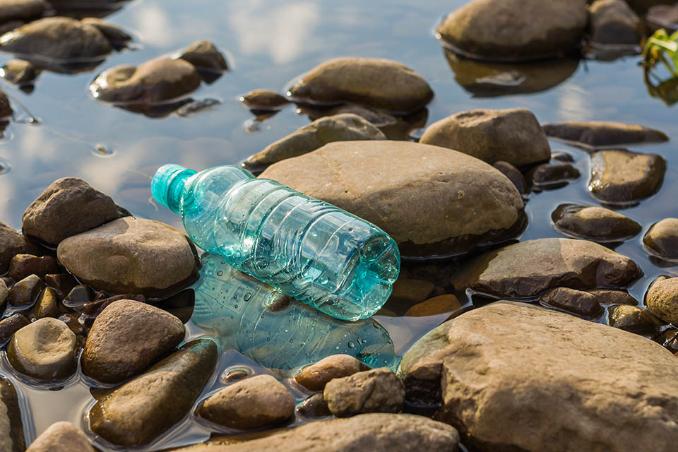 Plastic bottle sitting on rocks in water