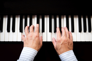 Hands playing a keyboard.