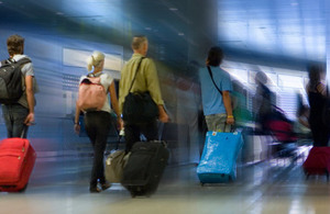 Airport passengers with luggage on walkway