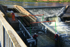 Workmen in the river bolting the fish pass extension into place