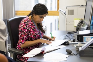 Doctor writing up notes in surgery