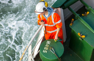 Female crew member working on deck of merchant ship