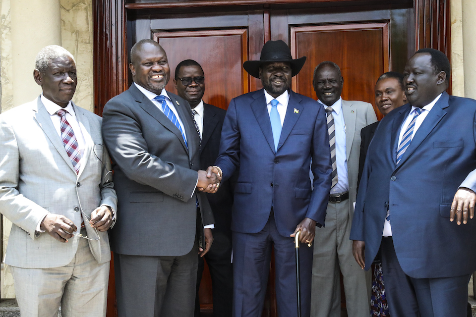 Salva Kiir Mayardit (centre right), President of the Republic of South Sudan, shakes hands with Riek Machar, opposition leader, at the Presidential Palace in Juba. (UN Photo)