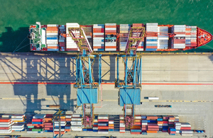 Aerial view of container ship in dock with cranes and freight containers
