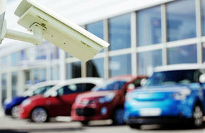 Photograph of a surveillance camera in front of parked cars