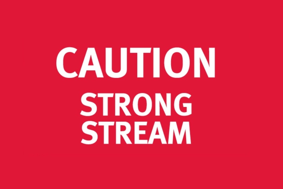A red sign with white text reading 'Caution: Strong stream'.