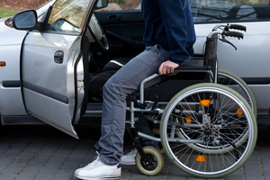 Man with wheelchair getting into car