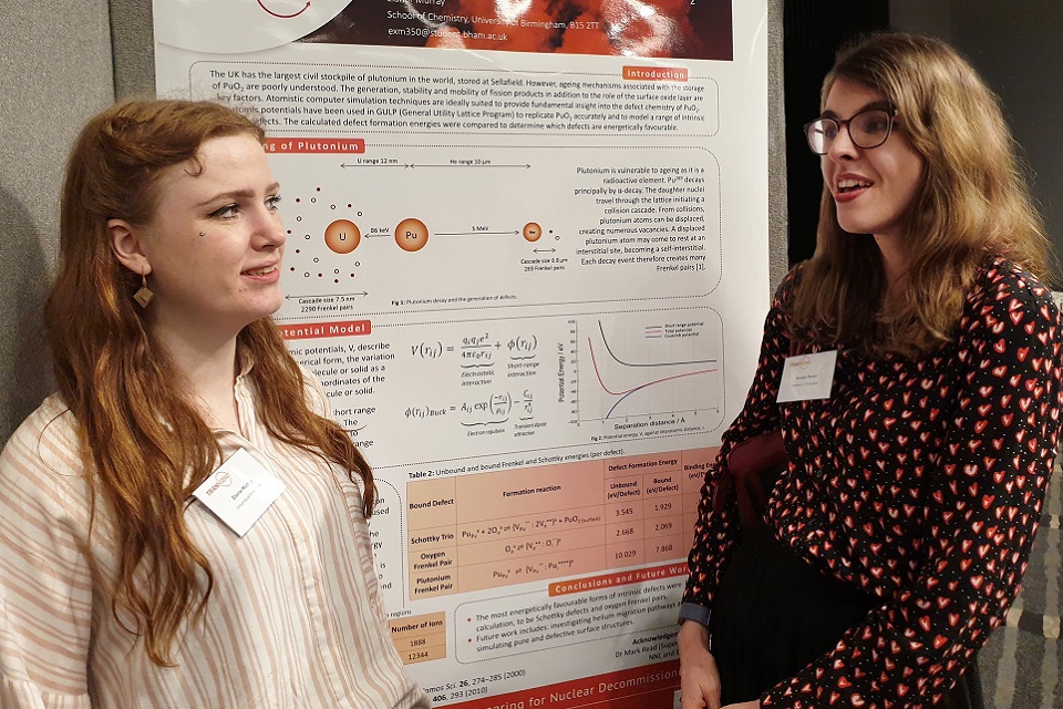 Two PhD students discussing a technical poster during a meeting of the TRANSCEND consortium