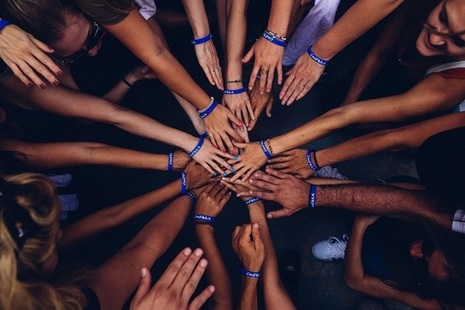Hands representing diverse communitties touching in order to make a circle.