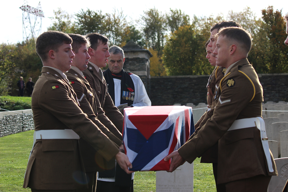 Soldiers from the 1st Battalion The Royal Anglian Regiment prepare to lower the coffin