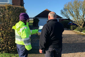 An Environment Agency officer helps a local resident sign up for flood warnings