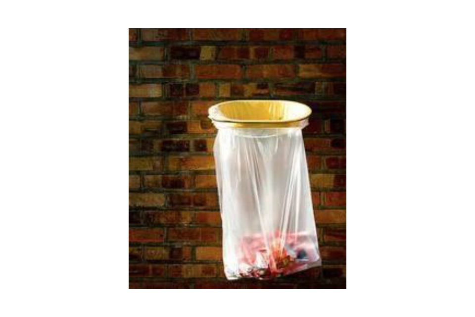 Clear transparent rubbish bin sack attached to hoop mounted on a brick wall