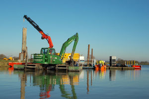Floating pontoons and equipment repairing a breach in the bank
