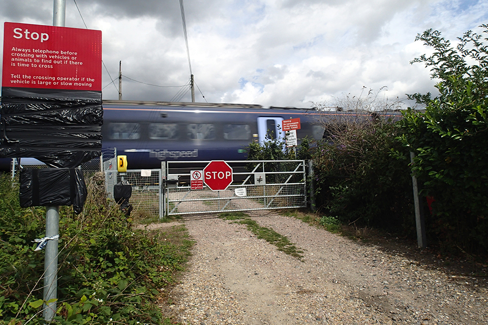 Frognal Farm crossing, after removal of the POGO system following the accident in 2017. A blue train is passing the crossing.