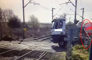 Image showing CCTV view of the stationary lorry and partly lowered level crossing barrier (highlighted) courtesy of Network Rail