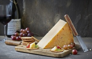Image of a cheeseboard with a glass of wine in the background