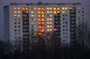 Big apartment block on a winter's evening with bare trees in foreground