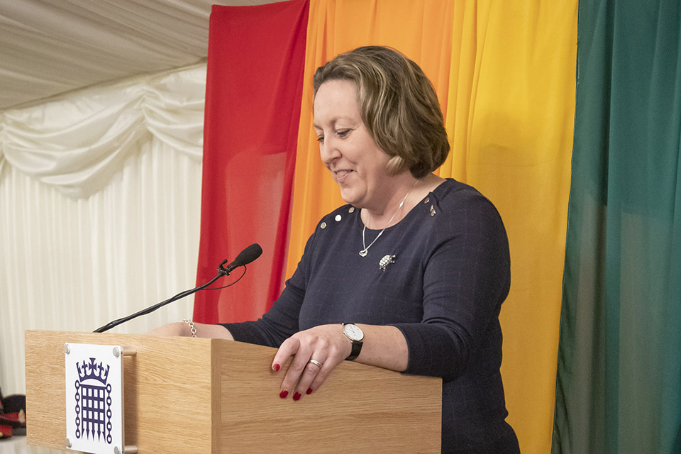 Minister of State for the Armed Forces Anne-Marie Trevelyan speaking at the LGB20 reception with a rainbow flag behind her