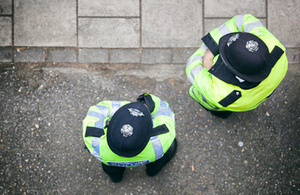 2 police officers standing in the street, photographed from above