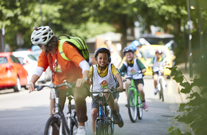 A group of children riding bicycles led by a Bikeability instructor