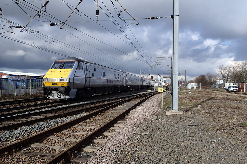 A train passing an Overhead line stanchion at the site of the fatal accident at Newark.