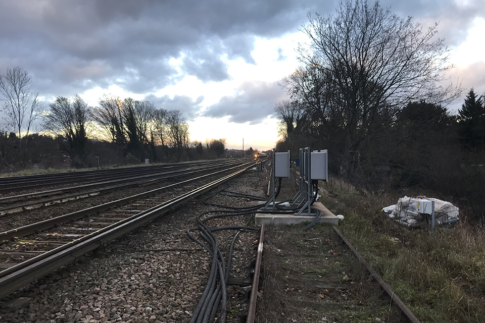 Winter image showing a dark sky, leafless trees and the railway line going into the distance. View is from the cess outside the limits of protection at Stoats Nest Junction.