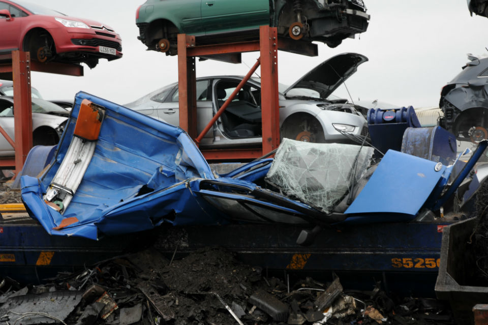 Photo of blue van being crushed at a scrap yard