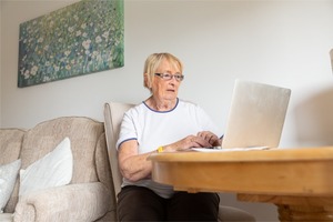 Older lady using laptop in her home