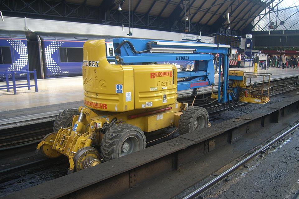 Blue and yellow four wheeled RRV at the platform at Glasgow Queen Street station