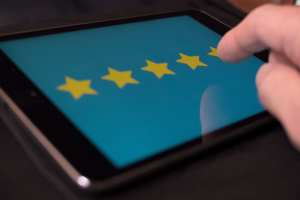 A person is rating 5 stars on a tablet device. 